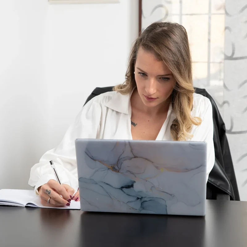 Psicologa Cecilia Scattolini, seduta sulla scrivania davanti al computer